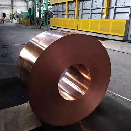Bobina pesada de fita de cobre no chão de fábrica ao lado do equipamento de processamento